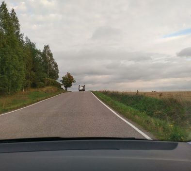 Auton ikkunasta otettu kuva, jossa edellä ajaa liikkuvan nuorisotyön matkailuauto, ympärillä peltomaisema. Kuvaaja: Aino Tormulainen.